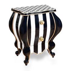 a black and white striped chest with gold knobs on the top, sitting against a white background