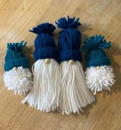 three blue and white tasselled hats sitting on top of a wooden floor