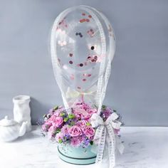 a vase filled with flowers on top of a table next to a glass ball shaped object