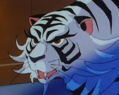 a white tiger with black stripes on it's face and chest, standing in front of a wall