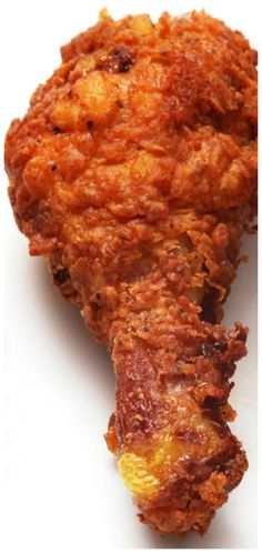 fried food on a white plate with a fork in the foreground and an image of chicken