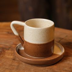 a cup and saucer sitting on top of a wooden table