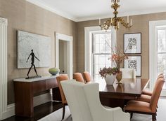 an elegant dining room with chandelier and art on the wall behind the table