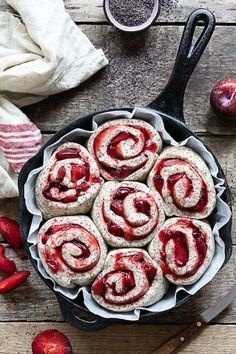 a pan filled with pastries sitting on top of a table next to sliced strawberries