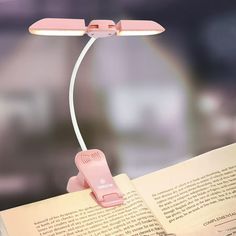 a pink light that is on top of an open book with a cord attached to it