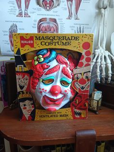 an image of a creepy clown mask on top of a wooden table in front of a poster