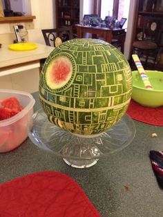 a watermelon cut in half sitting on top of a counter next to plastic containers