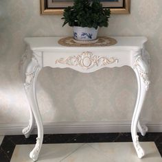 a white table with a potted plant on top