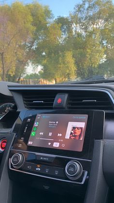 the interior of a car with an electronic device in the center console and other electronics on the dashboard