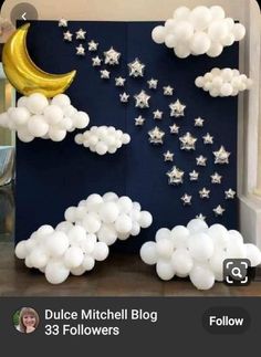 balloons are floating in the air next to a wall with stars and moon on it