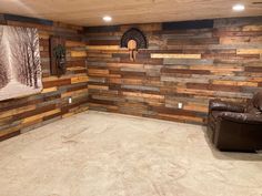 a living room with wood paneling and leather chair in it's center area