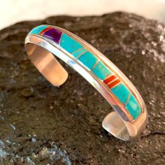 Gorgeous Classic Navajo Bracelet Handcrafted By 2 Known Master Artists Rose Ann Long And Calvin Begay. Beautiful Quality Channel Inlay Work With Rich Colors Of Turquoise, Red Coral And Sugilite. Native American Southwest Size 6 1/4” Total Inside Circumference Which Includes 5” Cuff Plus A Gap Of 1 1/4” Weighs 25.9 Grams 3/8” Wide Signed Hallmarks Rose Ann Long And Calvin Stamped Sterling New Condition Never Worn From Vintage 80’s Collection B157 Southwestern Sterling Silver Cuff Bracelet In Blue, Southwestern Style Sterling Silver Bracelet, Southwestern Adjustable Multi-stone Bracelets, Traditional Blue Sterling Silver Bracelets, Bohemian Blue Bracelets With Inlay, Southwestern Blue Sterling Silver Bracelet Gift, Southwestern Silver Multi-stone Bracelets, Southwestern Style Blue Sterling Silver Bracelet Gift, Southwestern Silver Bracelet With Multi-stone