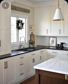 a kitchen with white cabinets and black counter tops is featured on instagram for the first time