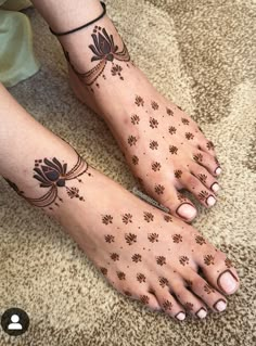 two feet with hendi tattoos on them, one is black and the other is brown