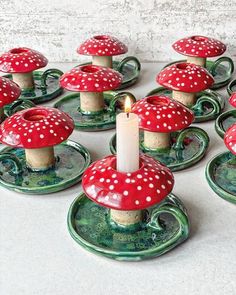 a table topped with green plates covered in red and white polka dot candlesticks