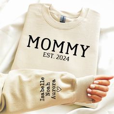 Custom made and personalized Mommy est. Sweatshirt available in lots of sweatshirt color options! Kids names are printed on the right sleeve. Sweatshirts are unisex and  50/50 cotton/polyester. To order please include the year you want below Mommy print and include the kids names in order you want.  If you have any questions please feel free to contact me. mommy sweatshirt, custom mommy shirt, mothers day gift, new mom gift, gift for mom, gift for wife, custom mommy est, mommy with names, mommy Mommy Sweatshirts, Personalized Sweatshirt For Mother's Day Gift, Mother's Day Gift Custom Print Sweatshirt, Mama Sweatshirt With Names, Mother's Day Sweatshirt With Custom Text, Mommy Shirt, Mommy Shirts, Kids Names, New Mom Gift