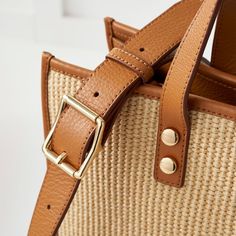 Crafted from a durable raffia-inspired fabric and high quality leather, our Essential Raffia Tote features a spacious, open-tote design with leather carry handles and an adjustable leather crossbody strap that can be swapped out for one of our colorful straps to create your own style. Add an embroidered monogram to add a personal touch to your new everyday tote.    15"w x 5"d x 12.5"h  Faux raffia with leather side panels and a soft linen lining.  Spot clean only with damp cloth.  Please see Pro Leather Bucket Bag With Detachable Strap In Natural Color, Natural Leather Bucket Bag With Detachable Strap, Brown Leather Trim Top Handle Bucket Bag, Modern Beige Straw Bag With Double Handle, Spring Woven Leather Top Handle Bag, Spring Top Handle Bag In Woven Leather, Beige Top Handle Bag With Woven Leather, Modern Woven Top Handle Bucket Bag, Modern Beige Woven Bucket Bag