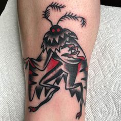 a tattoo on the leg of a person with a red and black design on it