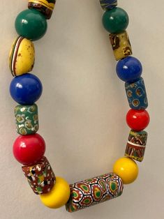 a multicolored beaded necklace hanging on a wall