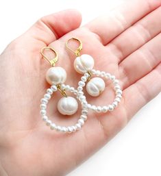 These pearl dangle earrings are the perfect bridal white pearl earrings for lovers of statement pearl earrings with a sleek geometric twist that would make ideal wedding earrings for bridesmaids. Two vintage inspired 10mm large white freshwater pearls sits wire wrapped to a dainty white pearl hoop to create a beautifully elegant drop length. Finished with a luxury gold vermeil lever back clasp for easy wearing. Simple and minimalist in style, these pearl hoop earrings are the perfect Christmas gift or birthday gift for lovers of pearl earrings and simplistic everyday jewellery. Chic Pearl Bridal Earrings Gift, White Pearl Embellished Hoop Earrings For Wedding, Chic White Pearl Charm Earrings, Chic Pearl Bridal Earrings, Chic Pearl Drop Chandelier Earrings For Gift, Chic Chandelier Earrings With Pearl Drop As Gift, Chic Chandelier Earrings With Pearl Drop, Minimalist Pearl Bridal Earrings With Matching Set, Chic Pearl White Pearl Earrings For Wedding