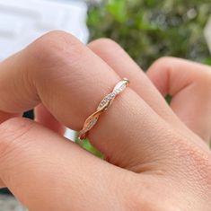 a woman's hand holding a gold and white diamond ring