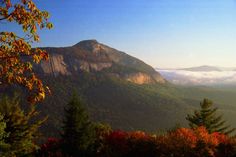 the mountains are covered in clouds and trees