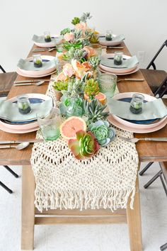 the table is set with succulents and plates