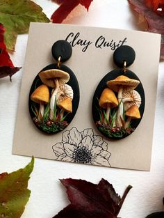 a pair of earrings with mushrooms on them