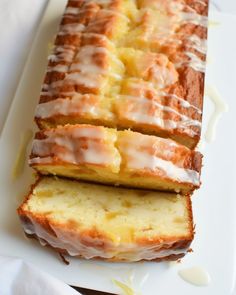 two slices of lemon pound cake on a white platter with drizzled icing