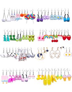 several pairs of earrings hanging from hooks on a white wall with rainbows and clouds