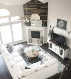 a living room filled with furniture and a flat screen tv on top of a fireplace