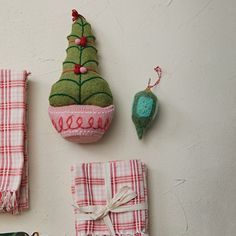 christmas decorations are displayed on the wall next to other items that have been made from fabric