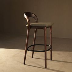 a wooden stool with a seat and back rests against a wall in an empty room