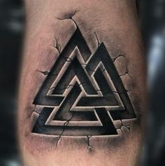 a man's leg with a black and grey tattoo on it