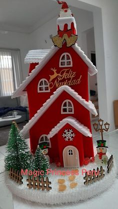 a red and white christmas house with santa clause on top