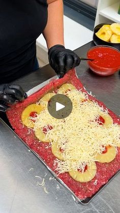 a woman in black gloves is making pizza