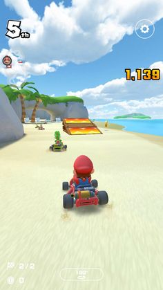 mario kart racing on the beach with other vehicles in front of him and his friend