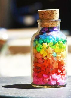 a jar filled with lots of different colored stars