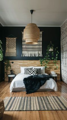 a bedroom with wood floors and black walls, white bedding and rugs on the floor