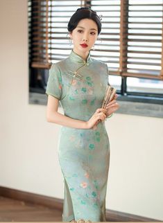 Embrace the exquisite elegance of this green Cheongsam dress, adorned with a delicate floral print and a traditional mandarin collar. The short sleeve design and knee-length cut are complemented by two subtle side slits, creating a timeless and sophisticated silhouette perfect for any special occasion. Size Guide: Please refer to the size guide picture before placing the order. Please leave your Height, Weight , Bust, Waist and Hip measurements in the Personalisation box so we could double check Green Cheongsam, Qipao Cheongsam, Qipao Dress, Chinese Design, Cheongsam Dress, Delicate Flower, Cheongsam, Style Moderne, Mandarin Collar