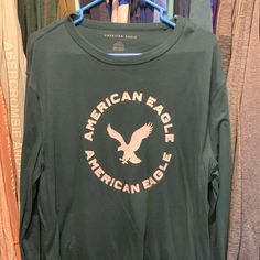 American Eagle Green Long Sleeve Shirt Never Worn Cotton Long Sleeve Shirt With Logo Print, Summer Long Sleeve Shirt With Logo Print, Green Long Sleeve Tops With Logo Print, Casual Long Sleeve Tops With Logo Print, Spring Long Sleeve Tops With Logo Print, Green Long Sleeve T-shirt With Logo Print, Green Long Sleeve T-shirt With Logo, Green Long Sleeve Shirt With Letter Print, Casual Long Sleeve Shirt With Logo Print