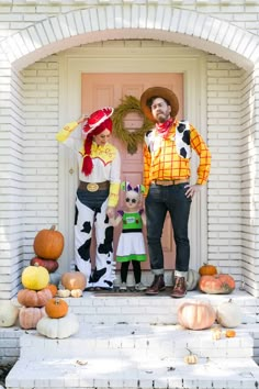 two people dressed as toy story characters standing in front of a door with pumpkins