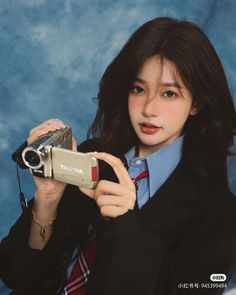 a woman holding a camera in front of her face