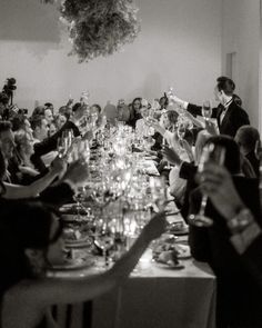 a group of people sitting at a long table with wine glasses in front of them