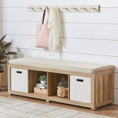 a wooden bench with two baskets and a pink bag hanging on the wall above it