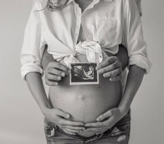 a pregnant woman is holding her belly in front of the camera