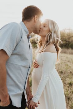 a pregnant woman kissing her husband on the cheek