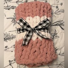 a pink and white blanket with a bow on it