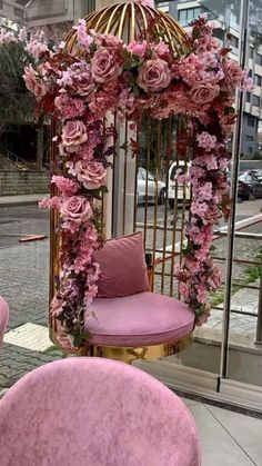 pink chairs and a birdcage decorated with flowers