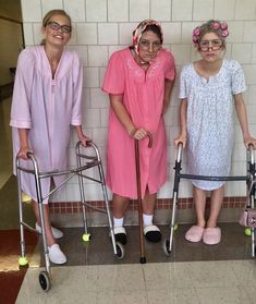 three women in pink dresses standing next to each other with crutches and canes